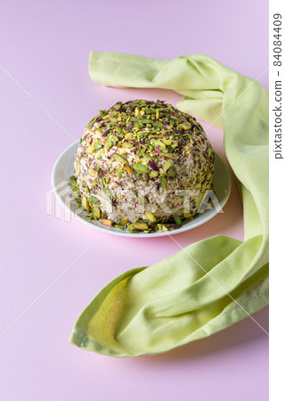 Halva with chopped pistachios and green napkin on pink Halva with chopped pistachios and green napkin on pink 84084409