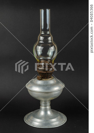 An old kerosene lamp against a gray background. 84085366