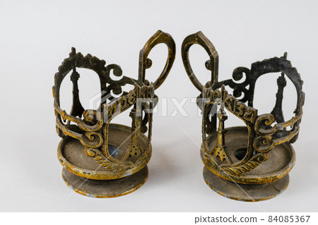 Two Old metal cup holders on a white background. Two Old metal cup holders on a white background. 84085367