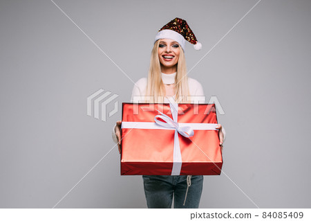 Pretty young woman is holding Christmas gift Pretty young woman is holding Christmas gift 84085409