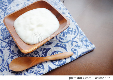 Yogurt scene in a square wooden bowl Yogurt scene in a square wooden bowl 84085486