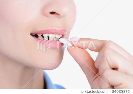 Womans face and female hand putting into mouth chewing gum Womans face and female hand putting into mouth chewing gum 84085875