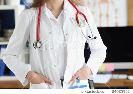 Head doctor in clinic with bunch of money in pocket of medical gown Head doctor in clinic with bunch of money in pocket of medical gown 84085901
