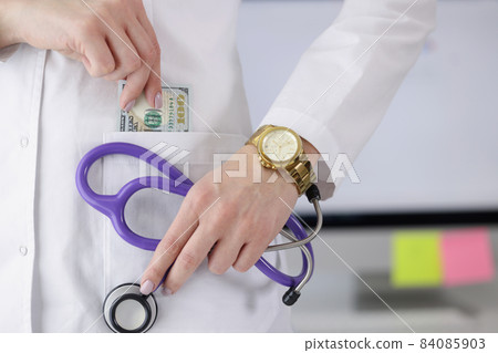 Doctor carry stethoscope tool and show piece of banknote in pocket Doctor carry stethoscope tool and show piece of banknote in pocket 84085903