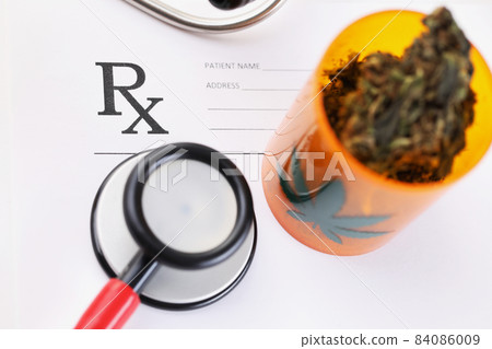 Jar with dried marijuana herb lying on blank medical prescription Jar with dried marijuana herb lying on blank medical prescription 84086009
