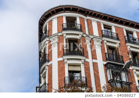 Old residential building facade against sky in Madrid 84086027