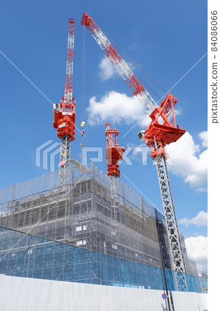 Condominium and tower crane under construction 84086066