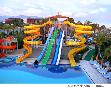 Water park water slides in the evening rays of the setting sun. 84086290