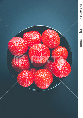 Strawberries in a bowl. Black background 84086373