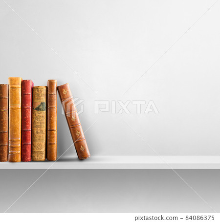 Row of old books on white shelf. Square background 84086375