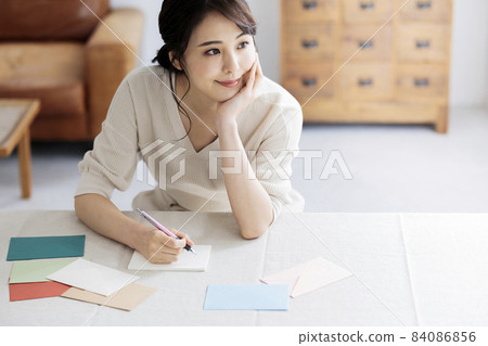 Young woman writing a letter by the window 84086856