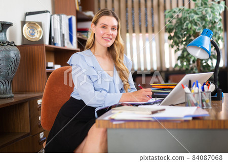 Successful businesswoman working with paperwork and laptop Successful businesswoman working with paperwork and laptop 84087068