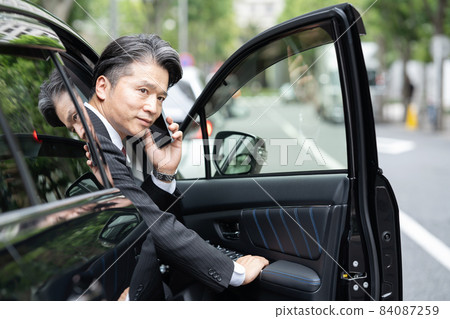 Male middle smartphone getting out of the car Male middle smartphone getting out of the car 84087259