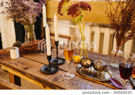 a glass of champagne, candles and silverware on a wooden table. a glass of champagne, candles and silverware on a wooden table. 84088930