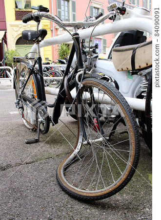Old broken bicycle with a crooked wheel 84090091