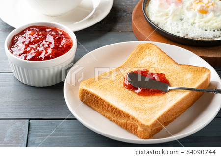 Strawberry jam on toasted bread 84090744