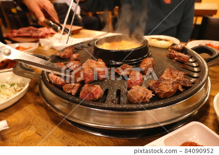 My friend and I are grilling meat. My friend and I are grilling meat. 84090952