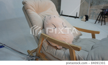 Soft toy lies on a rocking chair 84091301