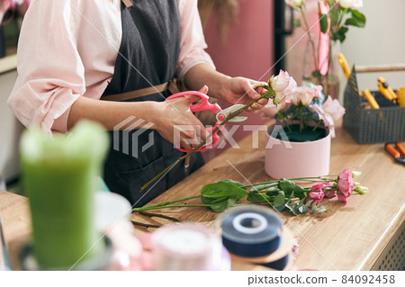 Professional florist young woman is doing bouquets at flower shop Professional florist young woman is doing bouquets at flower shop 84092458