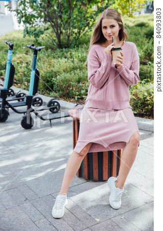 beautiful fashionable blonde woman in pink clothes drinking a coffee cocktail beautiful fashionable blonde woman in pink clothes drinking a coffee cocktail 84093803