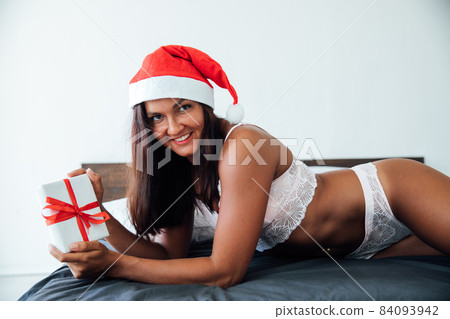 beautiful woman in lingerie for Christmas gift New Year in the bedroom beautiful woman in lingerie for Christmas gift New Year in the bedroom 84093942