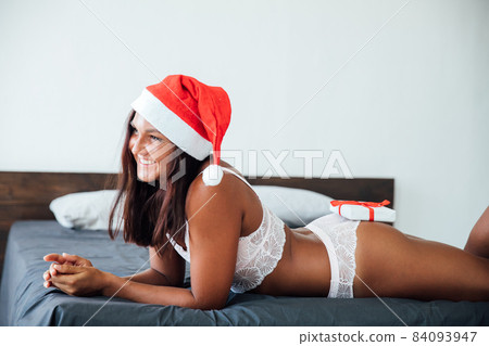 beautiful woman in lingerie for Christmas gift New Year in the bedroom beautiful woman in lingerie for Christmas gift New Year in the bedroom 84093947