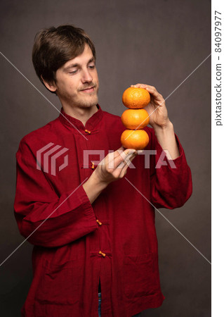 Young man with oranges on grey Young man with oranges on grey 84097977