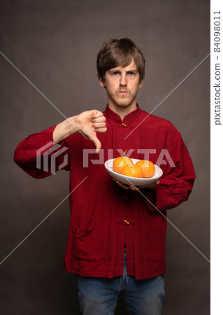 Young man with oranges on grey 84098011