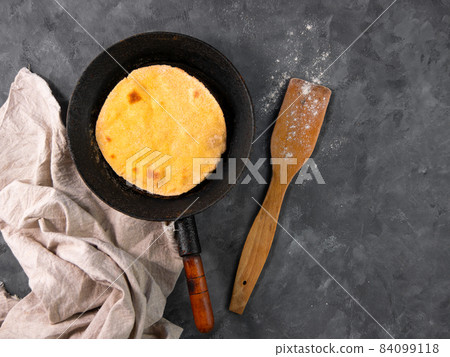 Homemade corn flatbread meal on frying pan linen cloth. Handmade mexican tortilla for wrapping. Traditional latin recipe 84099118