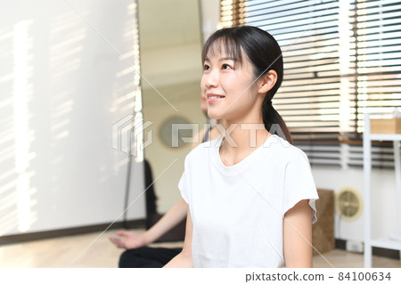 Profile of a young Asian woman doing yoga lessons in a yoga studio Profile of a young Asian woman doing yoga lessons in a yoga studio 84100634