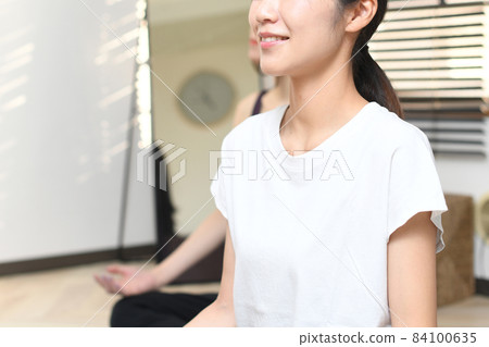 Profile of a young Asian woman doing yoga lessons in a yoga studio Profile of a young Asian woman doing yoga lessons in a yoga studio 84100635
