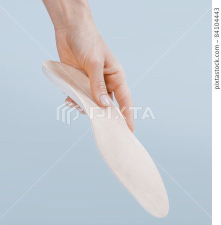 Orthopedic insole isolated on a blue background. Medical insoles. Treatment and prevention of flat feet and foot diseases. Foot care, feet comfort. Wear comfortable shoes. Flat Feet Correction. Orthopedic insole isolated on a blue background. Medical insoles. Treatment and prevention of flat feet and foot diseases. Foot care, feet comfort. Wear comfortable shoes. Flat Feet Correction. 84104443