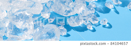 Close up crushed ice in sunlight on blue. Summer background refreshment concept 84104657
