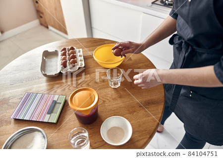young beautiful mixed race woman is preparing marshmallow at light modern kitchen home 84104751