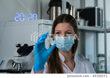 Doctor woman holding tube with Covid-19 Coronavirus vaccine, ready for vaccination against 2019-nCoV, 84106551