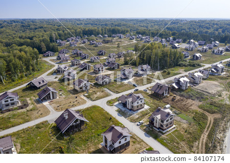 Aerial view of a cottage settlement under construction in the forest in Siberia Aerial view of a cottage settlement under construction in the forest in Siberia 84107174