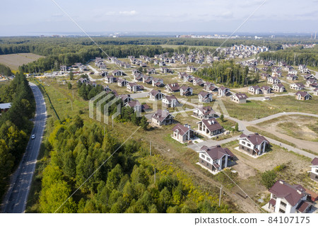 Aerial view of a cottage settlement under construction in the forest in Siberia 84107175