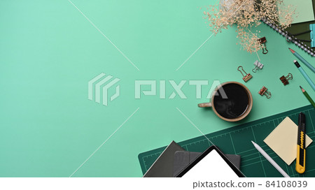 Above view cup of coffee, digital tablet and stationery on green background. 84108039