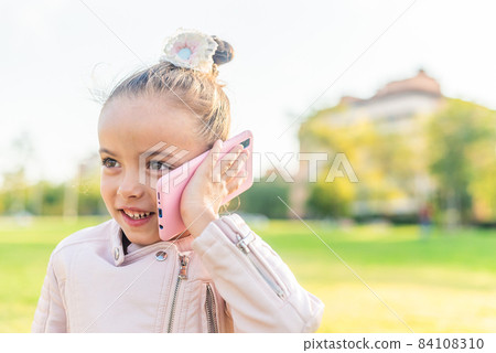girl talking on smart phone in the park 84108310