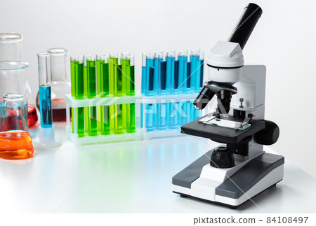 Laboratory microscope with colorful test tubes close up Laboratory microscope with colorful test tubes close up 84108497