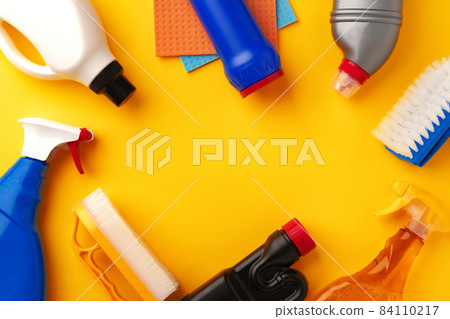 Set of cleaning supplies on yellow color background 84110217