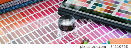 Magnifying glass lying on paper with color samples near digital tablet closeup 84110768