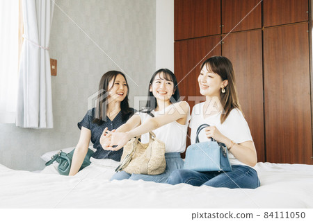 Women (beds) arriving at their travel accommodation 84111050