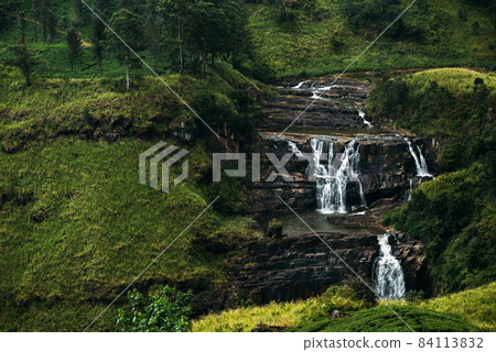 Waterfall among the green mountains. Waterfalls Of Sri Lanka. Landscapes Of Asia. Aerial photography. Tea plantation. Green hill. Mountain river. Small waterfall. Sri lanka Waterfall among the green mountains. Waterfalls Of Sri Lanka. Landscapes Of Asia. Aerial photography. Tea plantation. Green hill. Mountain river. Small waterfall. Sri lanka 84113832