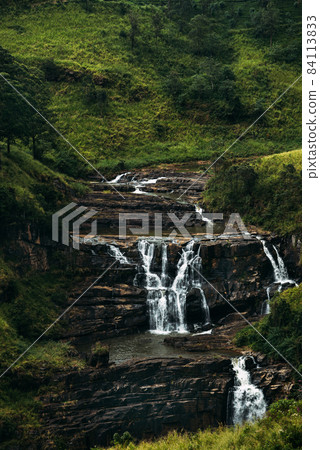 Waterfall among the green mountains. Waterfalls Of Sri Lanka. Landscapes Of Asia. Aerial photography. Tea plantation. Green hill. Mountain river. Small waterfall. Sri lanka Waterfall among the green mountains. Waterfalls Of Sri Lanka. Landscapes Of Asia. Aerial photography. Tea plantation. Green hill. Mountain river. Small waterfall. Sri lanka 84113833