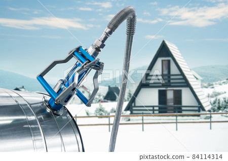 CNG nozzle with gas tank on a background of winter house 84114314