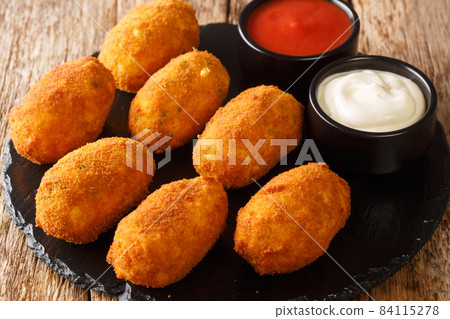 Croquetas de Bacalao Cod Croquettes with sauces close up in the slate plate . Horizontal Croquetas de Bacalao Cod Croquettes with sauces close up in the slate plate . Horizontal 84115278
