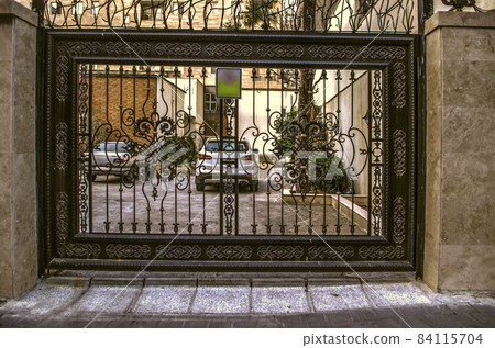 Sliding iron gates covered with a black decorative wrought iron lattice and with patterns painted with silver paint in the city of Tehran Sliding iron gates covered with a black decorative wrought iron lattice and with patterns painted with silver paint in the city of Tehran 84115704