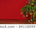red background, christmas tree, spruce branches with New Year's toys, background for a New Year card 84118099