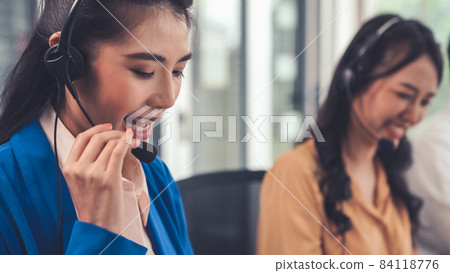 Businesswoman wearing headset working actively in office Businesswoman wearing headset working actively in office 84118776